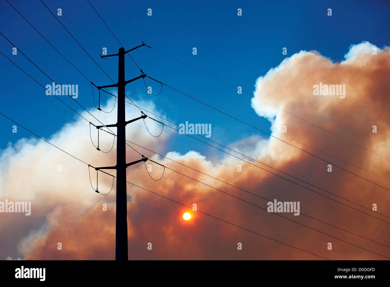 Linee elettriche ad alta tensione, Sun e il pennacchio di fumo da infuria la Colorado wildfire, Colorado, STATI UNITI D'AMERICA Foto Stock