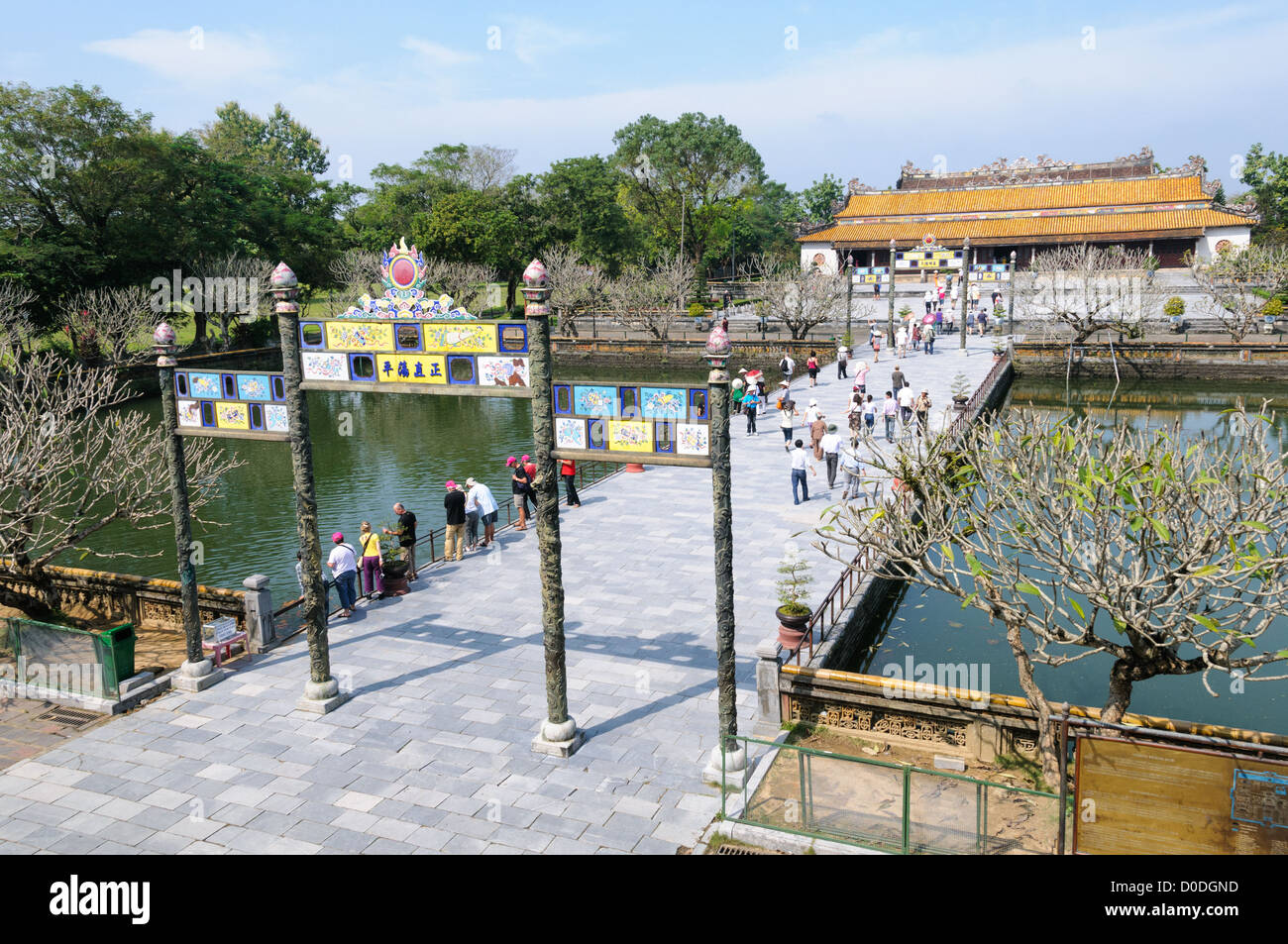 Imperial City Entrance Bridge Hue Vietnam // HUE, Vietnam - turisti sul ponte all'ingresso principale della città imperiale di Hue, Vietnam. Un palazzo auto-chiuso e fortificato, il complesso comprende la città Proibita viola, che era il santuario interno della casa imperiale, nonché templi, cortili, giardini e altri edifici. Gran parte della città imperiale fu danneggiata o distrutta durante la guerra del Vietnam. È ora dichiarato patrimonio dell'umanità dell'UNESCO. Foto Stock