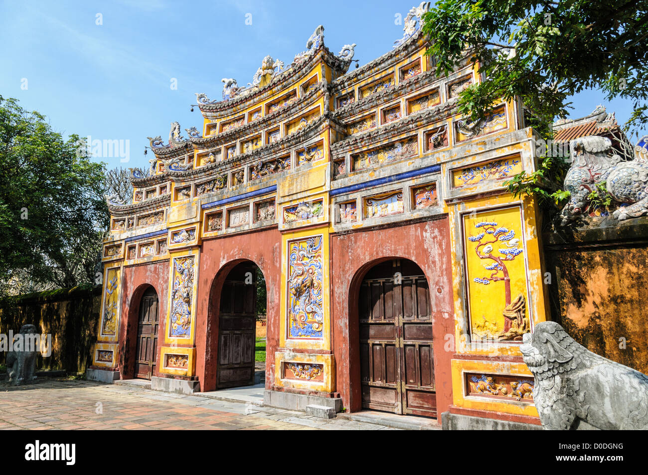 Imperial City Gate Hue Vietnam // HUE, Vietnam — Un cancello presso la città imperiale di Hue, Vietnam. Un palazzo auto-chiuso e fortificato, il complesso comprende la città Proibita viola, che era il santuario interno della casa imperiale, nonché templi, cortili, giardini e altri edifici. Gran parte della città imperiale fu danneggiata o distrutta durante la guerra del Vietnam. È ora dichiarato patrimonio dell'umanità dell'UNESCO. Foto Stock
