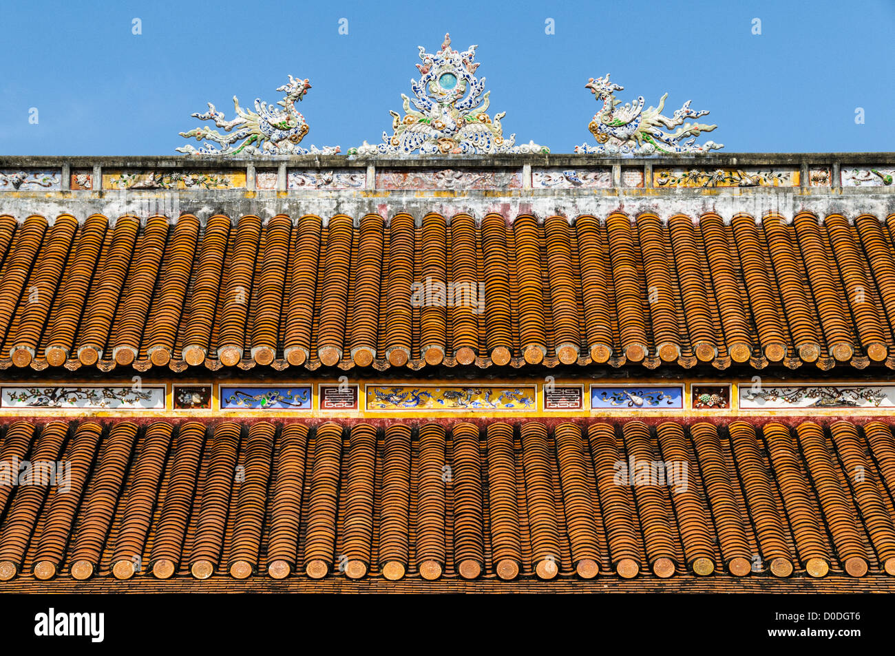 Imperial City Decorated Roof Hue Vietnam // HUE, Vietnam — il tetto decorato con decorazioni ornamentali di un edificio restaurato nella città imperiale di Hue, Vietnam. Un palazzo auto-chiuso e fortificato, il complesso comprende la città Proibita viola, che era il santuario interno della casa imperiale, nonché templi, cortili, giardini e altri edifici. Gran parte della città imperiale fu danneggiata o distrutta durante la guerra del Vietnam. È ora dichiarato patrimonio dell'umanità dell'UNESCO. Foto Stock