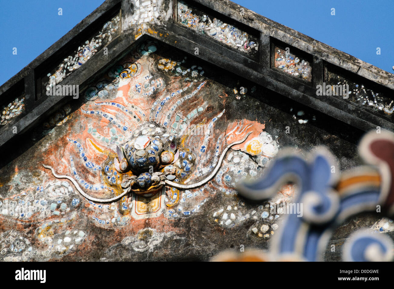 Imperial City Decorative Art Hue Vietnam // HUE, Vietnam — Arte decorativa su un edificio della città Imperiale di Hue, Vietnam. Un palazzo auto-chiuso e fortificato, il complesso comprende la città Proibita viola, che era il santuario interno della casa imperiale, nonché templi, cortili, giardini e altri edifici. Gran parte della città imperiale fu danneggiata o distrutta durante la guerra del Vietnam. È ora dichiarato patrimonio dell'umanità dell'UNESCO. Foto Stock