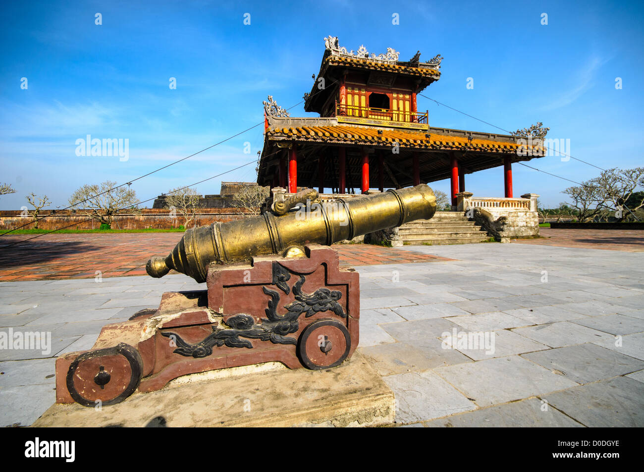 Imperial City Cannon e Pagoda Hue Vietnam // HUE, Vietnam — Un cannone in primo piano, con pagoda restaurata sullo sfondo fuori dal fossato della città imperiale di Hue, Vietnam. Un palazzo auto-chiuso e fortificato, il complesso comprende la città Proibita viola, che era il santuario interno della casa imperiale, nonché templi, cortili, giardini e altri edifici. Gran parte della città imperiale fu danneggiata o distrutta durante la guerra del Vietnam. È ora dichiarato patrimonio dell'umanità dell'UNESCO. Foto Stock