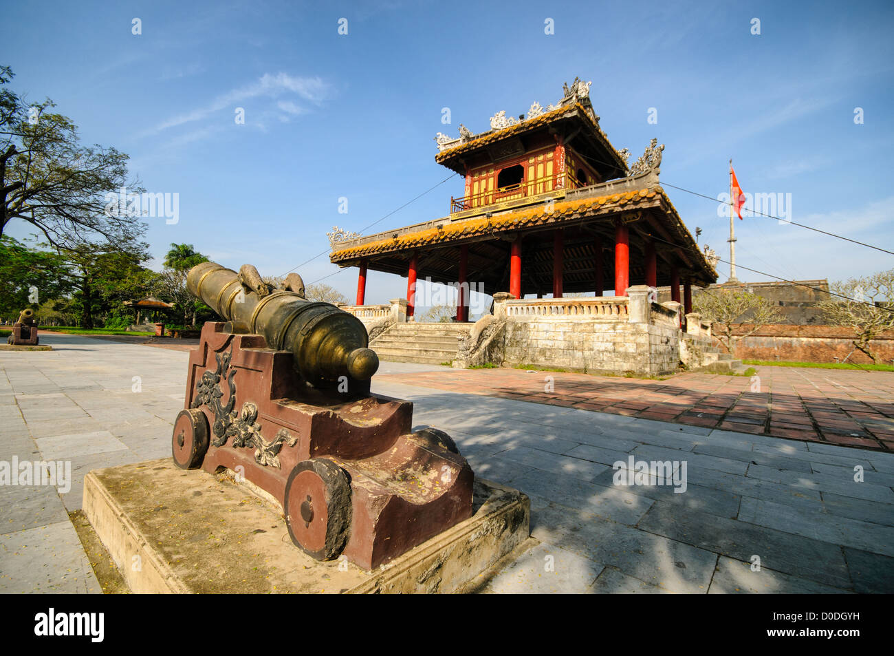 Imperial City Cannon e Pagoda Hue Vietnam // HUE, Vietnam — Un cannone e una pagoda fuori dal fossato della città imperiale di Hue, Vietnam. Un palazzo auto-chiuso e fortificato, il complesso comprende la città Proibita viola, che era il santuario interno della casa imperiale, nonché templi, cortili, giardini e altri edifici. Gran parte della città imperiale fu danneggiata o distrutta durante la guerra del Vietnam. È ora dichiarato patrimonio dell'umanità dell'UNESCO. Foto Stock