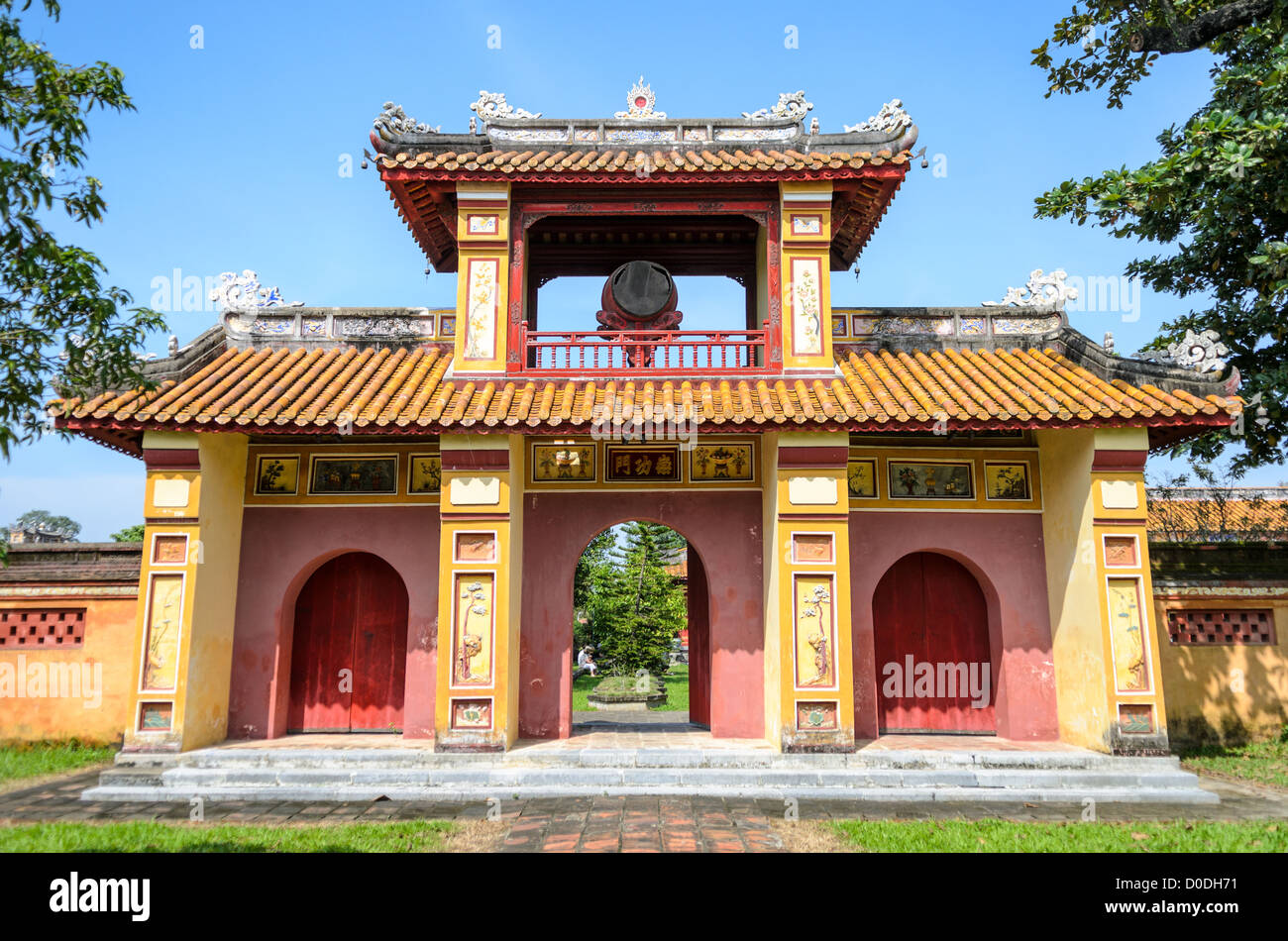 Imperial City Painted Gate Hue Vietnam // HUE, Vietnam — Un cancello dipinto presso la città imperiale di Hue, Vietnam. Un palazzo auto-chiuso e fortificato, il complesso comprende la città Proibita viola, che era il santuario interno della casa imperiale, nonché templi, cortili, giardini e altri edifici. Gran parte della città imperiale fu danneggiata o distrutta durante la guerra del Vietnam. È ora dichiarato patrimonio dell'umanità dell'UNESCO. Questo cancello era un ingresso al Dien Tho Residence. Costruito nel 1804, questo complesso era l'alloggio della Regina madre o della nonna dell'Imperatore. Foto Stock