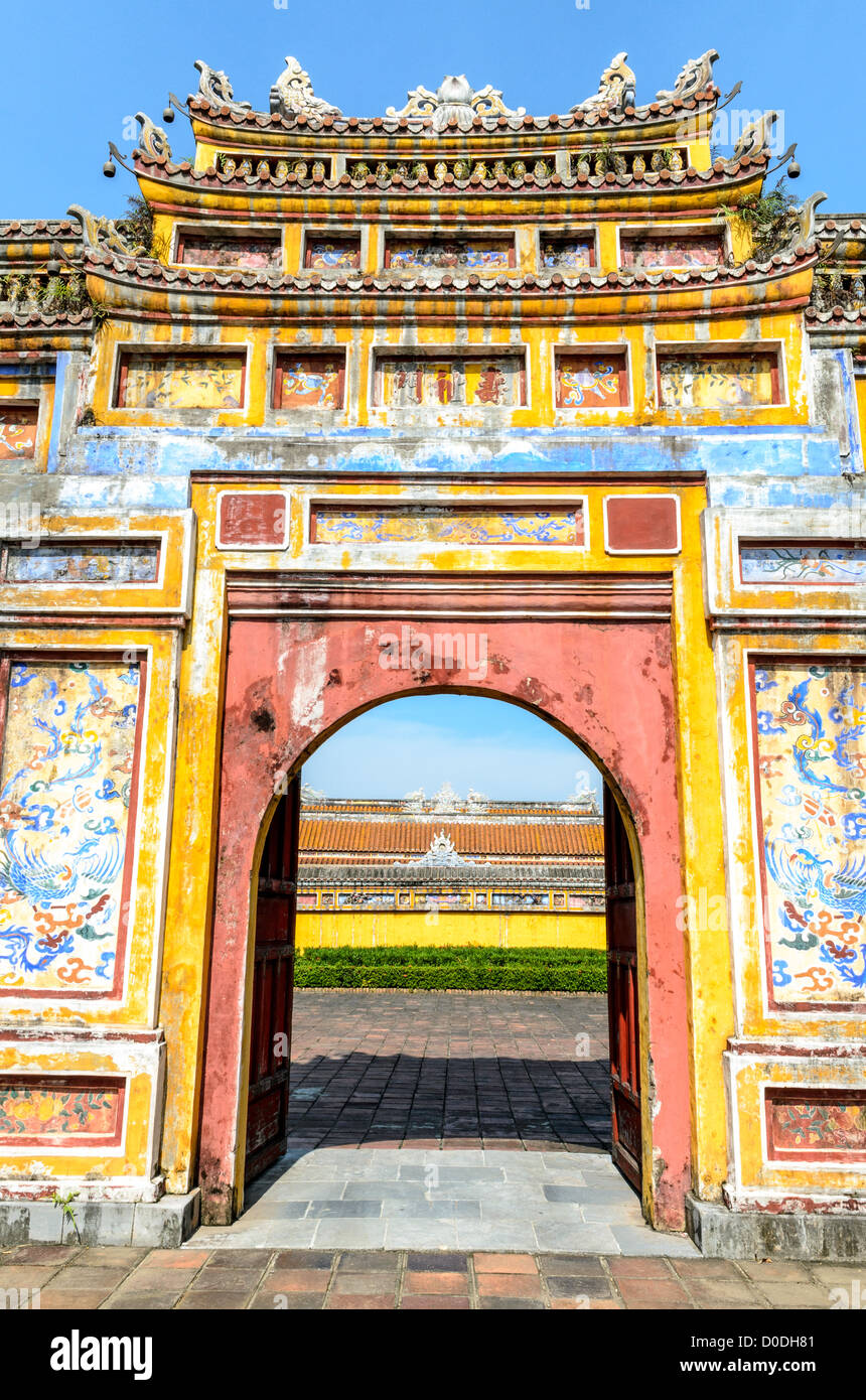 HUE, Vietnam — Un cancello dipinto presso la città imperiale di Hue, Vietnam. Un palazzo auto-chiuso e fortificato, il complesso comprende la città Proibita viola, che era il santuario interno della casa imperiale, nonché templi, cortili, giardini e altri edifici. Gran parte della città imperiale fu danneggiata o distrutta durante la guerra del Vietnam. È ora dichiarato patrimonio dell'umanità dell'UNESCO. Questo cancello era un ingresso al Dien Tho Residence. Costruito nel 1804, questo complesso era l'alloggio della Regina madre o della nonna dell'Imperatore. Foto Stock