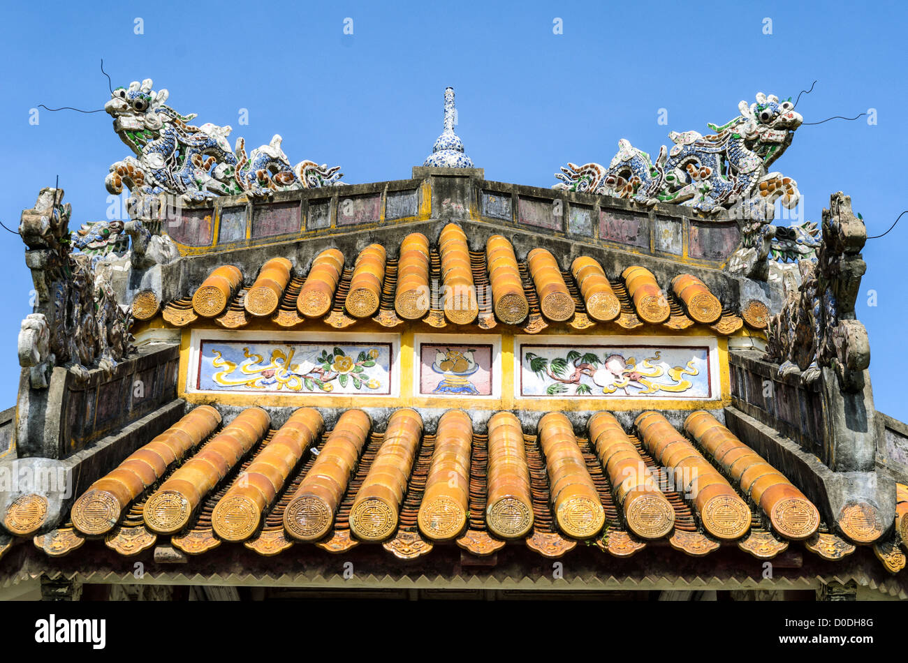 Imperial City Pagoda Roof Hue Vietnam // HUE, Vietnam — il tetto ornato di una pagoda restaurata nella città imperiale di Hue, Vietnam. Un palazzo auto-chiuso e fortificato, il complesso comprende la città Proibita viola, che era il santuario interno della casa imperiale, nonché templi, cortili, giardini e altri edifici. Gran parte della città imperiale fu danneggiata o distrutta durante la guerra del Vietnam. È ora dichiarato patrimonio dell'umanità dell'UNESCO. Foto Stock