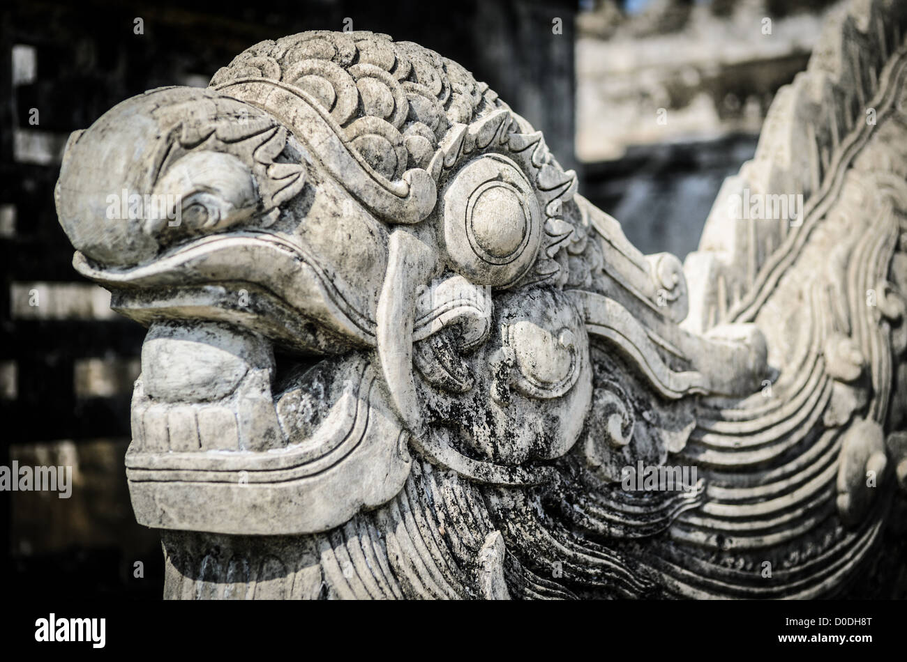 Imperial City Stone Dragon Hue Vietnam // HUE, Vietnam — Un drago di pietra nella città imperiale di Hue, Vietnam. Un palazzo auto-chiuso e fortificato, il complesso comprende la città Proibita viola, che era il santuario interno della casa imperiale, nonché templi, cortili, giardini e altri edifici. Gran parte della città imperiale fu danneggiata o distrutta durante la guerra del Vietnam. È ora dichiarato patrimonio dell'umanità dell'UNESCO. Foto Stock