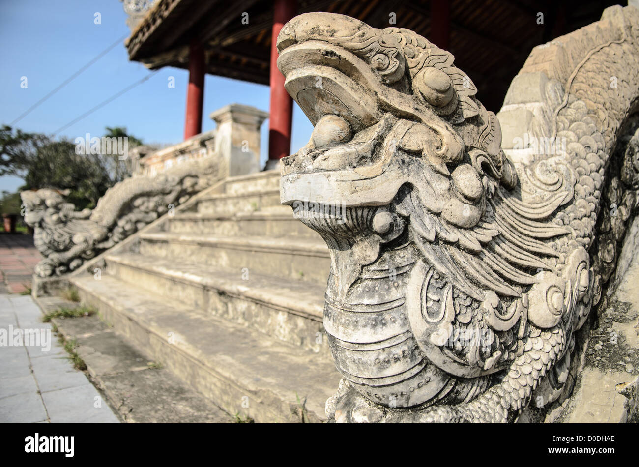 Statua del drago della città imperiale Hue Vietnam // HUE, Vietnam — presso la città imperiale di Hue, Vietnam. Un palazzo auto-chiuso e fortificato, il complesso comprende la città Proibita viola, che era il santuario interno della casa imperiale, nonché templi, cortili, giardini e altri edifici. Gran parte della città imperiale fu danneggiata o distrutta durante la guerra del Vietnam. È ora dichiarato patrimonio dell'umanità dell'UNESCO. Foto Stock