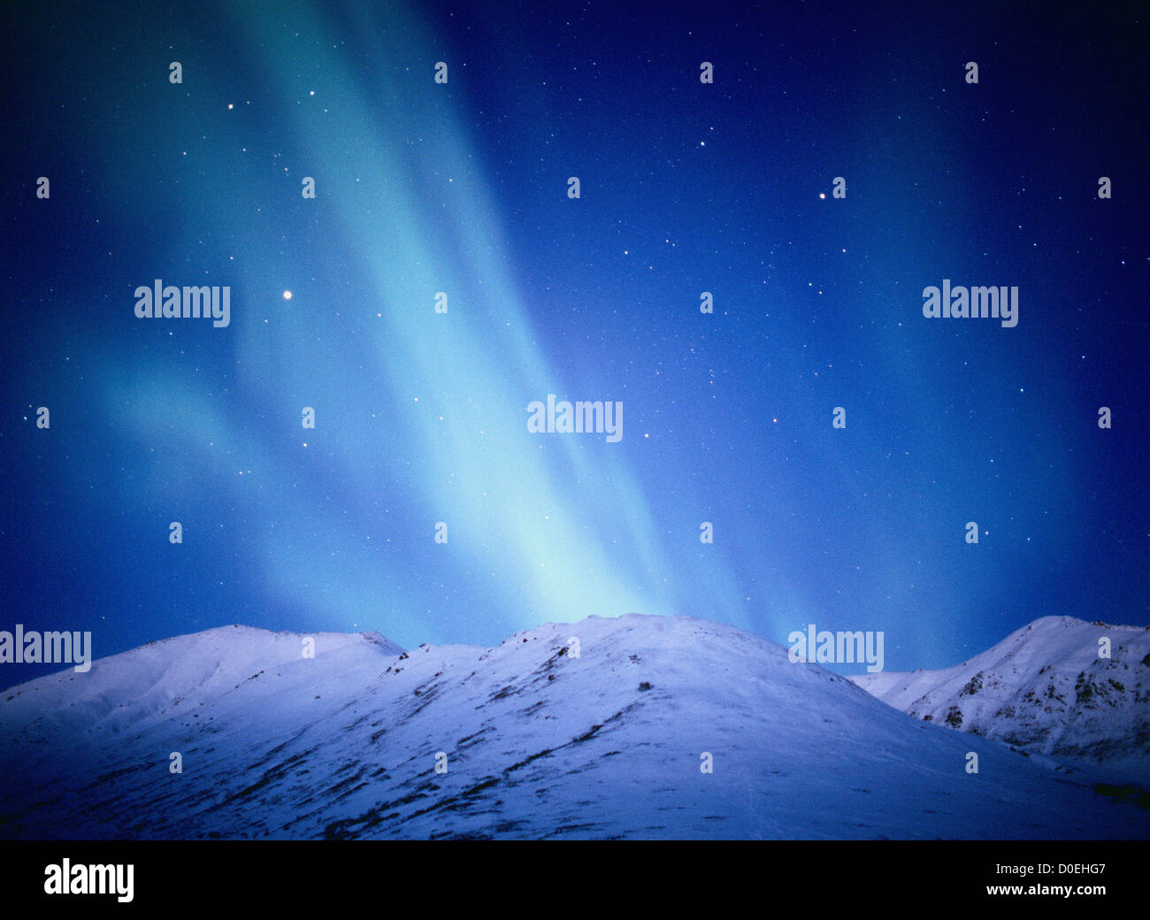 Aurora blu-verde sopra il Snow-Covered Talkeetna montagne durante alle prime luci dell'alba Foto Stock