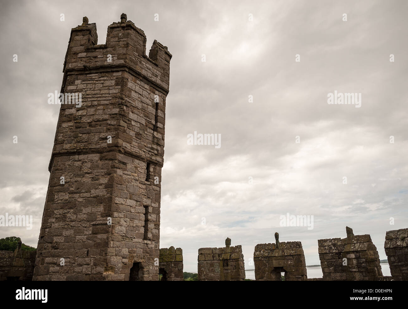 CAERNARFON, Galles — nuvole tempestose con bastioni al castello di Caernarfon nel Galles nord-occidentale. Un castello originariamente sorgeva sul sito risalente alla fine dell'XI secolo, ma alla fine del XIII secolo re Edoardo i commissionò una nuova struttura che si erge fino ad oggi. Ha torri caratteristiche ed è uno dei castelli meglio conservati della serie commissionata da Edoardo I. Foto Stock