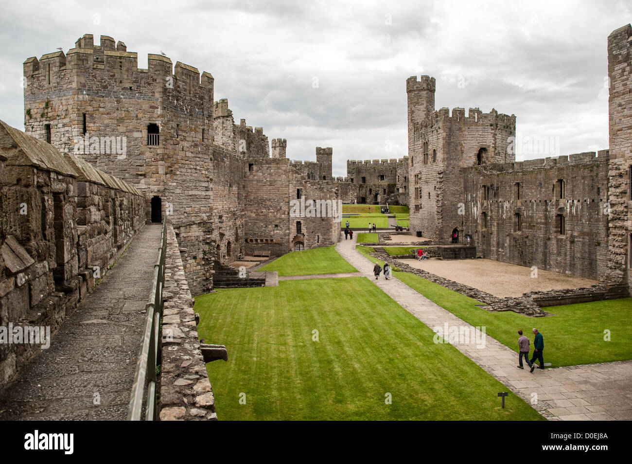 CAERNARFON, Galles — il cortile del castello di Caernarfon nel Galles nord-occidentale. Un castello originariamente sorgeva sul sito risalente alla fine dell'XI secolo, ma alla fine del XIII secolo re Edoardo i commissionò una nuova struttura che si erge fino ad oggi. Ha torri caratteristiche ed è uno dei castelli meglio conservati della serie commissionata da Edoardo I. Foto Stock