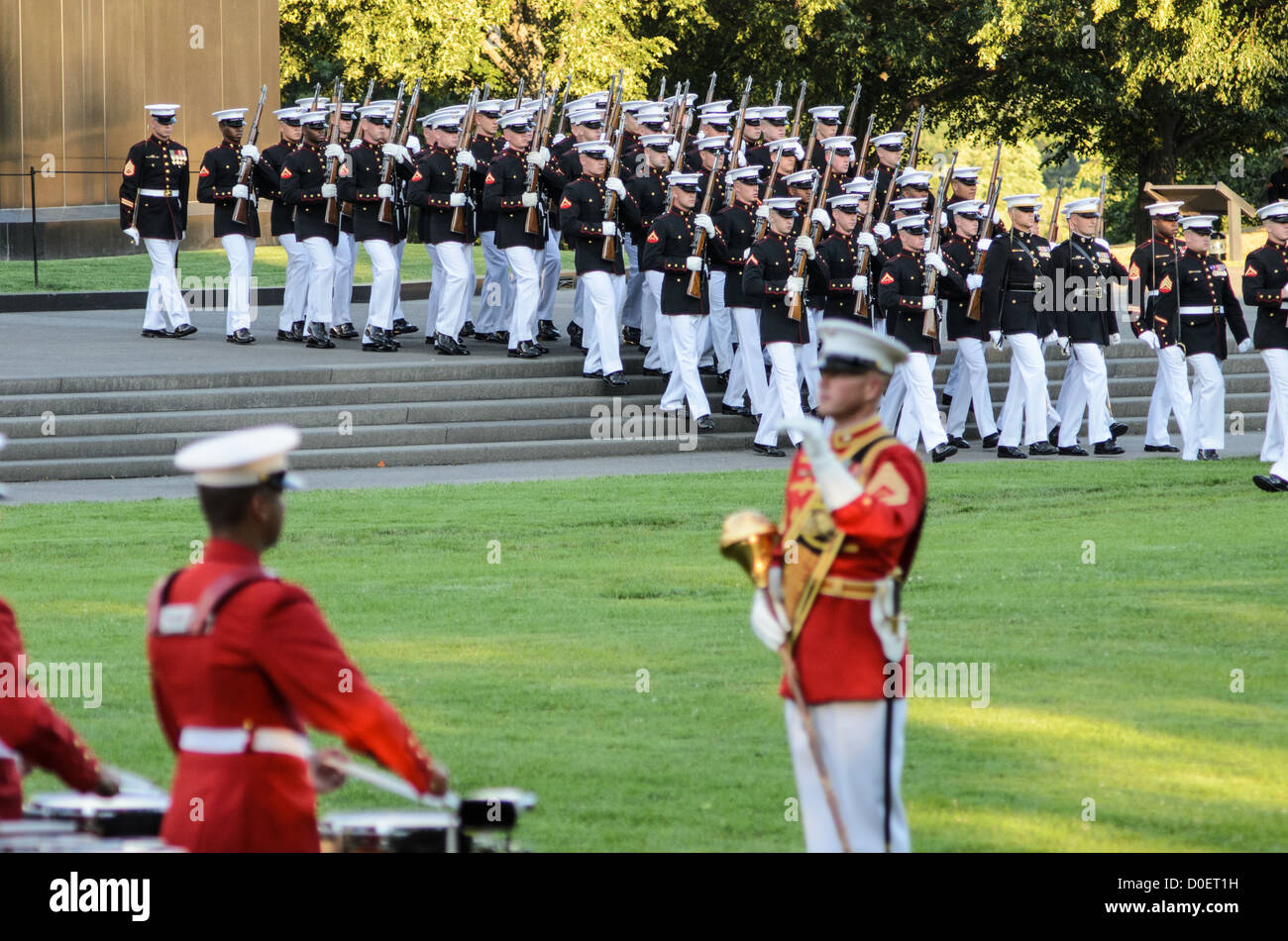 ARLINGTON, Virginia, Stati Uniti - i Marines si esibiscono durante la Marine Corps Sunset Parade al Marine Corps War Memorial, noto anche come Iwo Jima Memorial, ad Arlington, Virginia. La Sunset Parade, che presenta il Silent Drill Platoon e il Comandante's Own Drum and Bugle Corps, si svolge il martedì sera durante i mesi estivi. L'iconico memoriale, raffigurante la bandiera che innalza su Iwo Jima, funge da sfondo drammatico per questa antica tradizione militare. Foto Stock