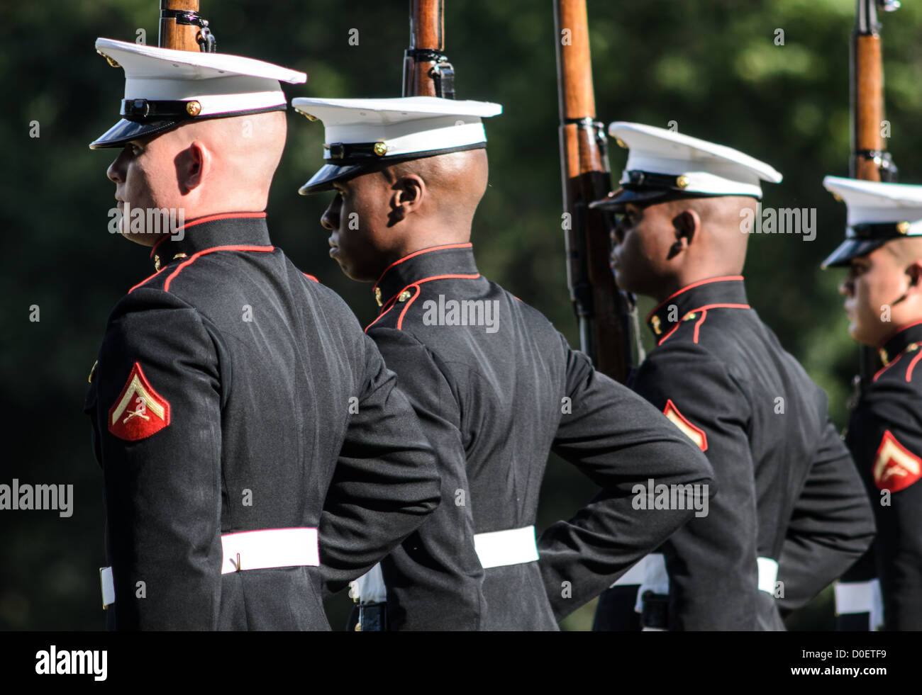 ARLINGTON, Virginia, Stati Uniti - il Marine Corps Silent Drill Platoon si esibisce durante la Sunset Parade al Marine Corps War Memorial, noto anche come Iwo Jima Memorial, ad Arlington, Virginia. La Sunset Parade, caratterizzata da movimenti di precisione e musica, si svolge il martedì sera durante i mesi estivi. L'iconico memoriale, raffigurante la bandiera che innalza su Iwo Jima, funge da sfondo drammatico per questa antica tradizione militare. Foto Stock