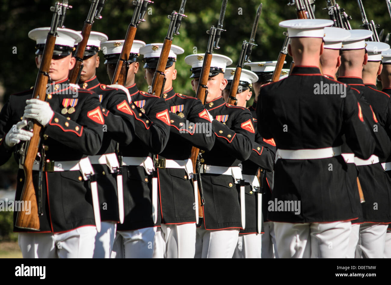 ARLINGTON, Virginia, Stati Uniti - il Marine Corps Silent Drill Platoon si esibisce durante la Sunset Parade al Marine Corps War Memorial, noto anche come Iwo Jima Memorial, ad Arlington, Virginia. La Sunset Parade, caratterizzata da movimenti di precisione e musica, si svolge il martedì sera durante i mesi estivi. L'iconico memoriale, raffigurante la bandiera che innalza su Iwo Jima, funge da sfondo drammatico per questa antica tradizione militare. Foto Stock