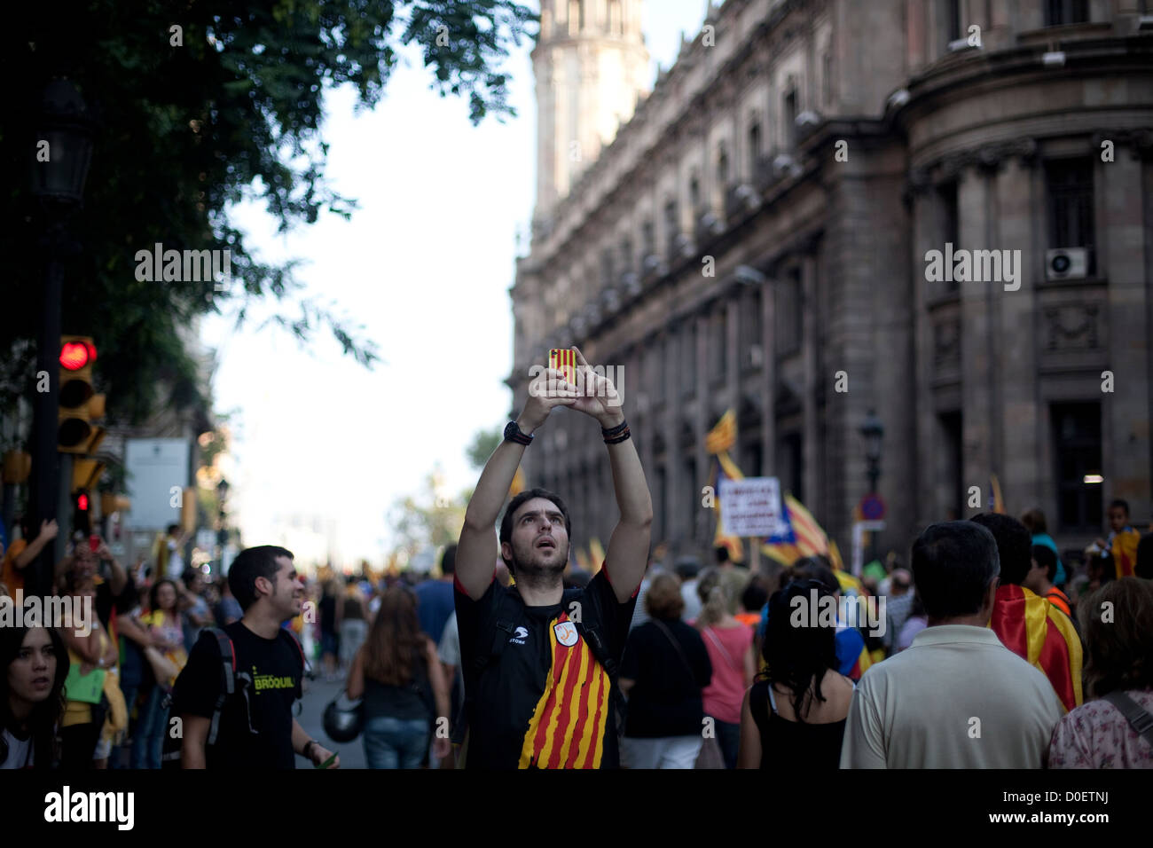 Uomo con una bandiera catalana sulla t-shirt di scattare una foto con un cellulare durante il catalano della giornata nazionale marzo a Barcellona Foto Stock