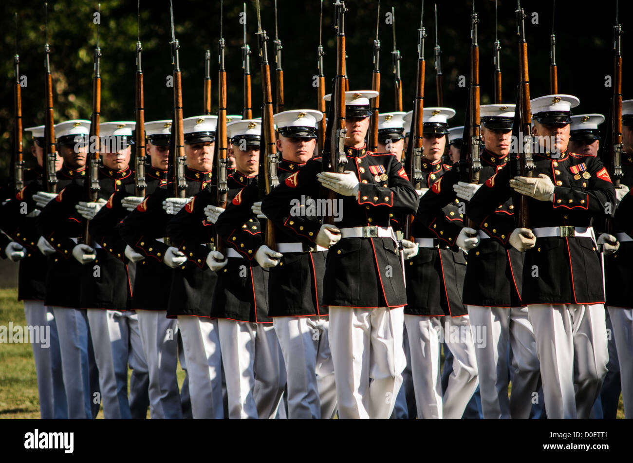 ARLINGTON, Virginia, Stati Uniti - il Marine Corps Silent Drill Platoon si esibisce durante la Sunset Parade al Marine Corps War Memorial, noto anche come Iwo Jima Memorial, ad Arlington, Virginia. La Sunset Parade, caratterizzata da movimenti di precisione e musica, si svolge il martedì sera durante i mesi estivi. L'iconico memoriale, raffigurante la bandiera che innalza su Iwo Jima, funge da sfondo drammatico per questa antica tradizione militare. Foto Stock