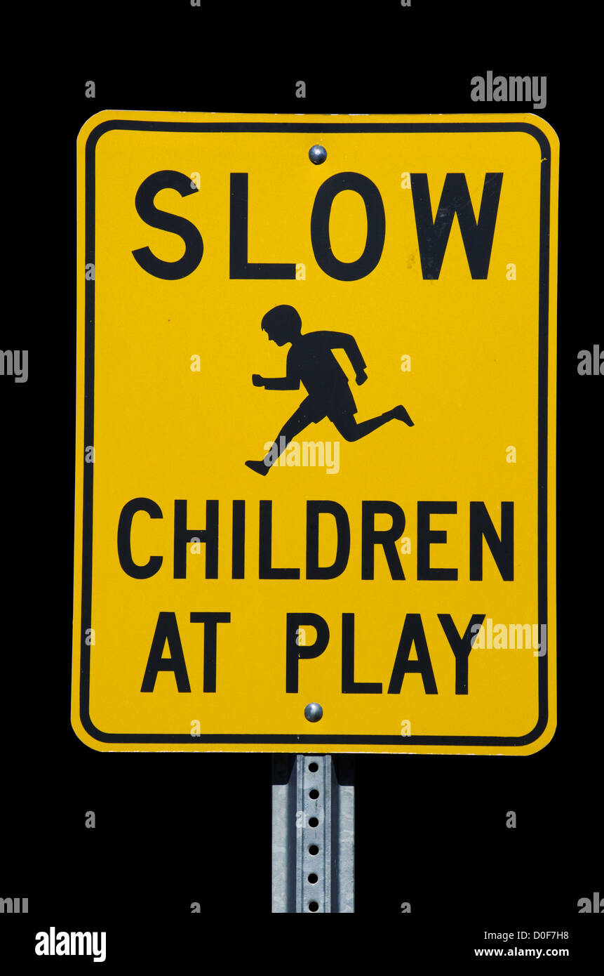 Rallentare i bambini a giocare un cartello stradale con sfondo nero Foto Stock