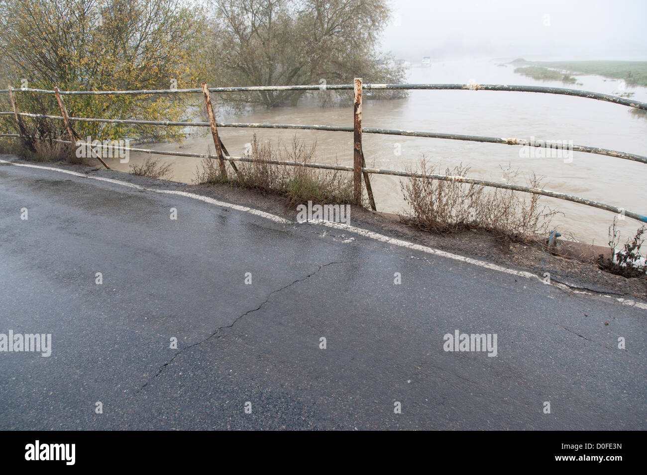 2012-11-24 Northamptonshire UK. Come il fiume Nene continua a traboccare Hardwater Croce dal mulino Hardwater sta mostrando segni di stress con una crepa che figurano nella superficie stradale. Foto Stock