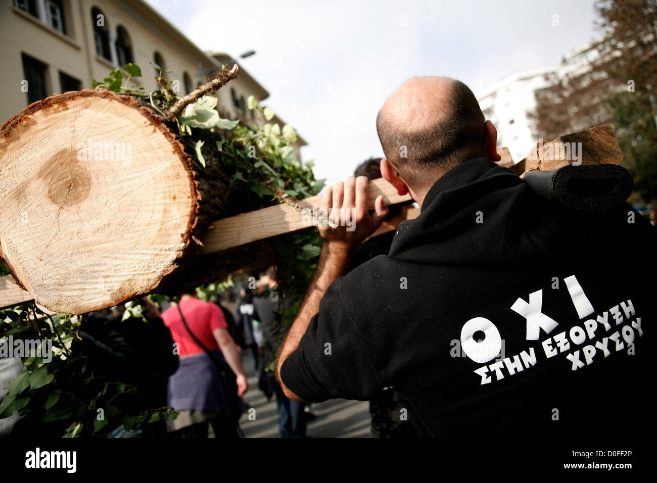 Salonicco, Grecia. Il 24 novembre 2012. I manifestanti che indossano felpe con cappuccio che recita "No alle miniere d'oro" e portante gli alberi raffiguranti le foreste funerale. Migliaia di persone hanno invaso le strade di Salonicco per protestare contro gli sforzi compiuti dalla Hellas oro, una controllata dell'impresa canadese Eldorado oro, alla mia la cava di Skouries sul Monte Kakkavos, nella penisola di Halkidiki e la città di Kilkis nella Grecia settentrionale. Foto Stock