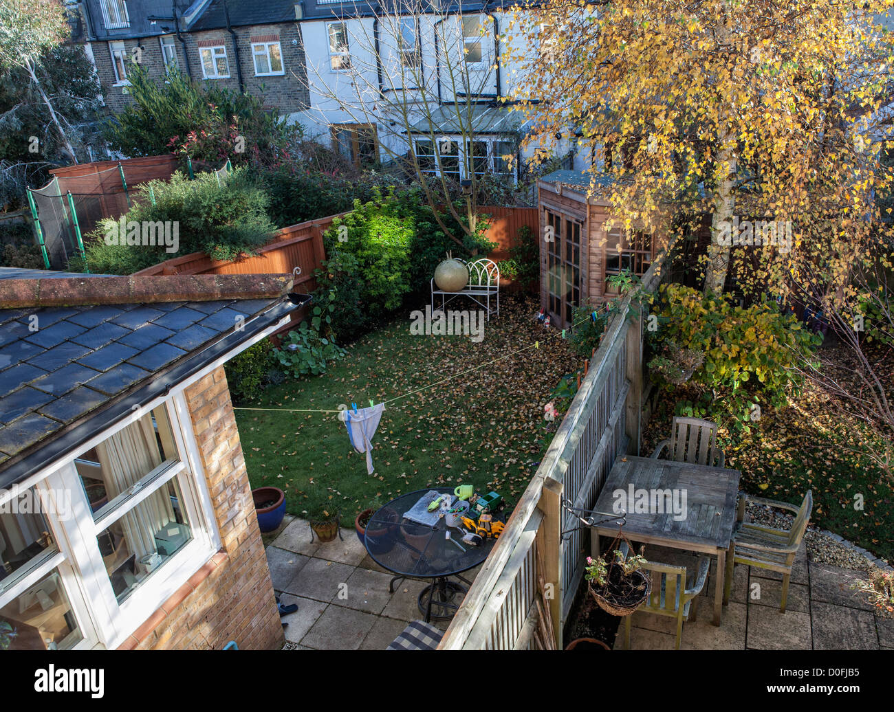 Autunno in suburbia - caduta foglie, scartato giocattoli e trampolino vuoto Foto Stock