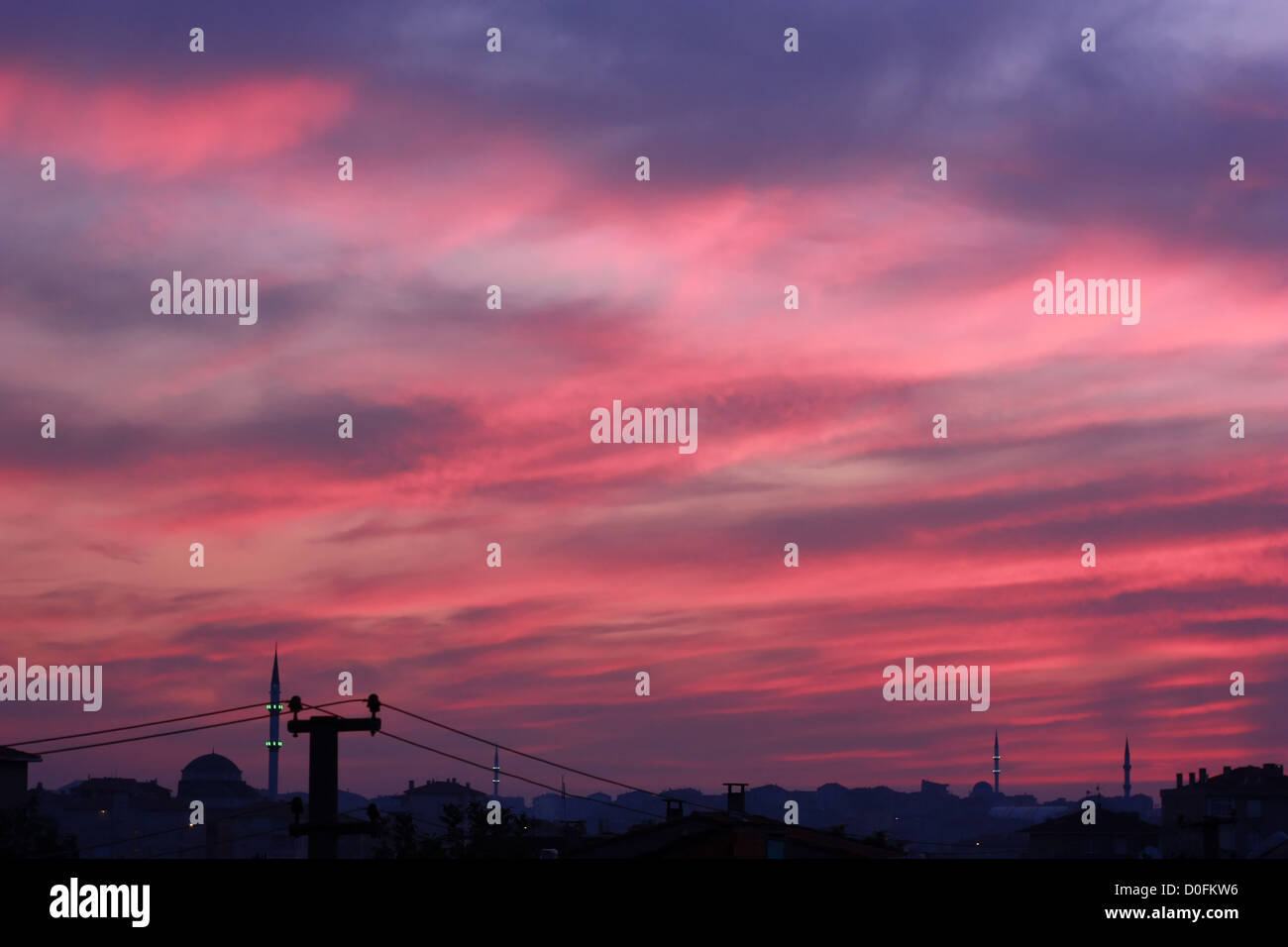 Tramonto con scena di rosso le nuvole e la silhouette della città sullo sfondo Foto Stock