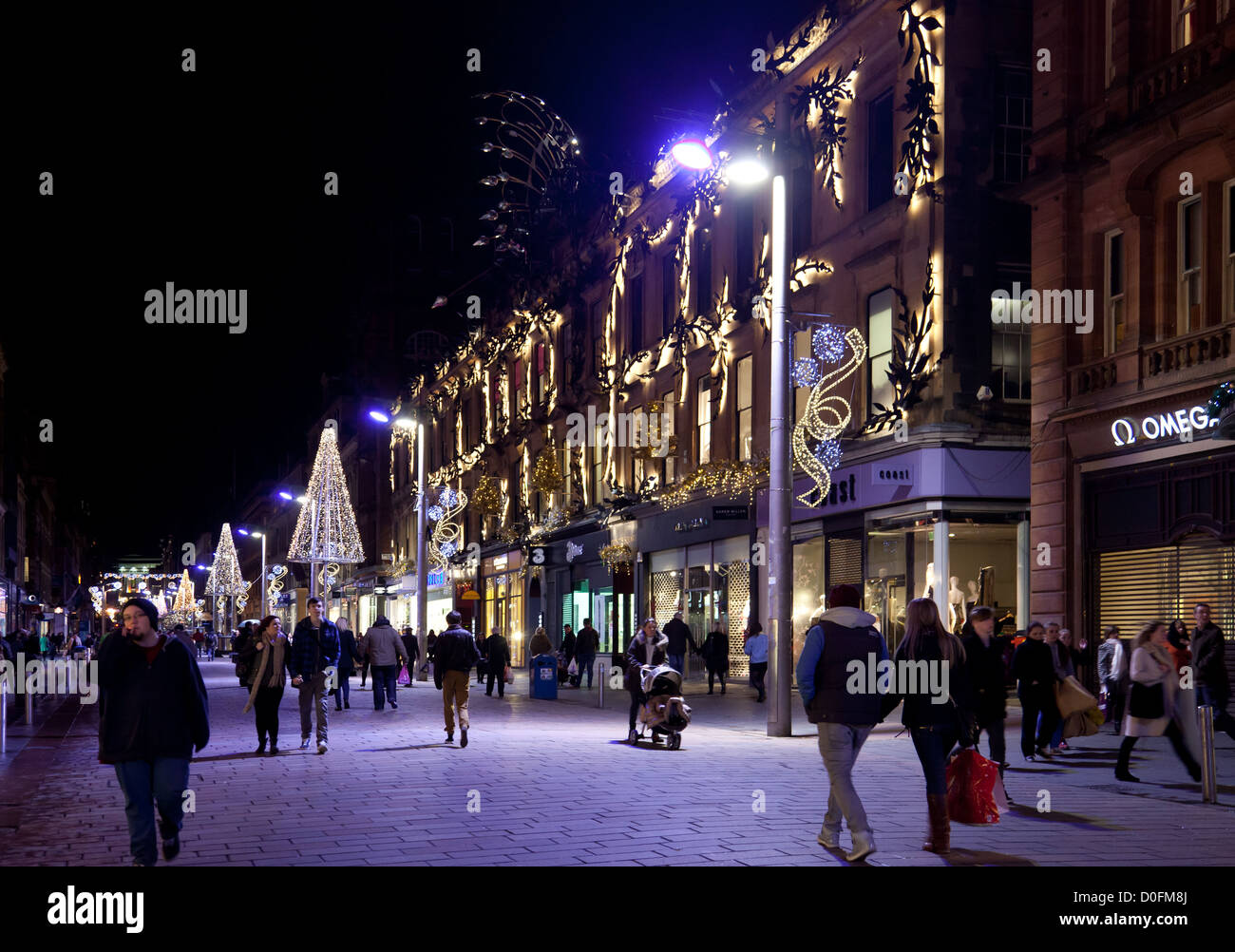 Buchanan Street Glasgow di notte - Novembre. I lavoratori e gli acquirenti sotto le luci blu. Princes Square. Le luci di Natale. Scozia Foto Stock