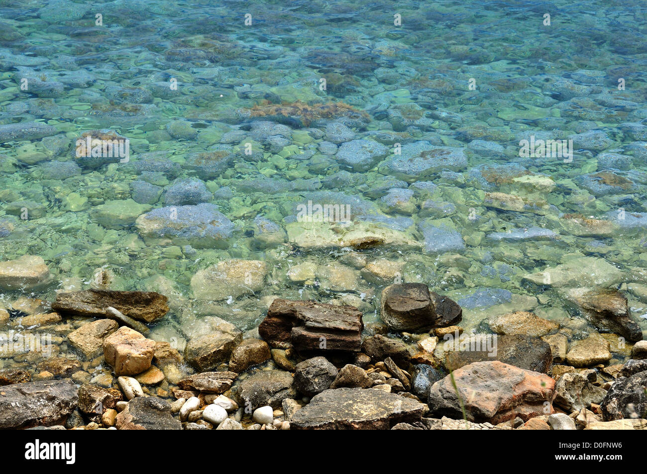 Blu chiaro di acqua di mare e la spiaggia di pietra dello sfondo. Foto Stock