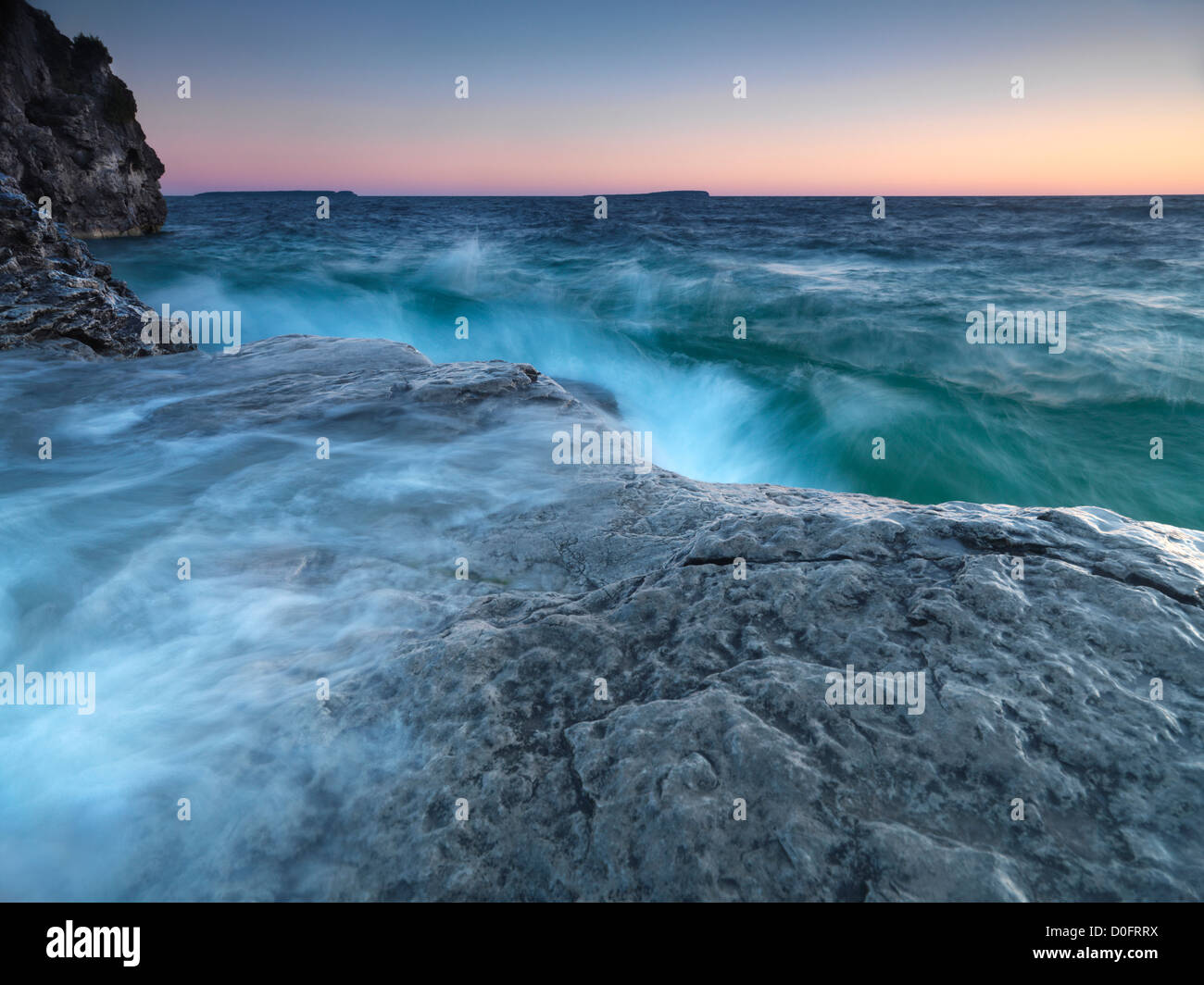 Bellissima alba oltre le acque tempestose del Georgian Bay che colpiscono la sua costa rocciosa. Bruce Peninsula National Park, Ontario, Canada. Foto Stock