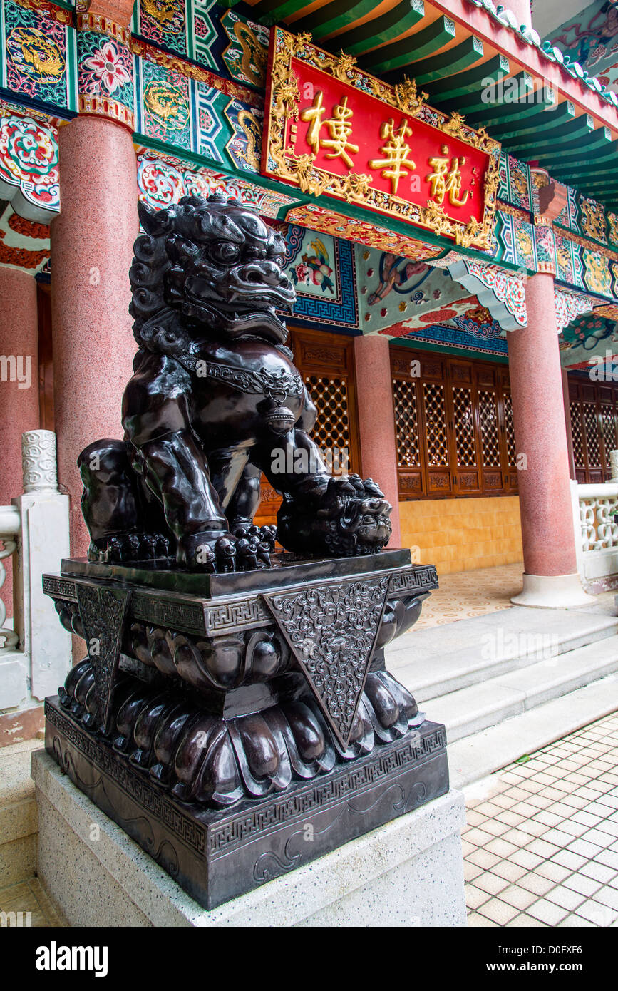 Un custode cinese lion all'ingresso di Istituto di Yuen Yuen, Tsuen Wan, Hong Kong, Cina Foto Stock