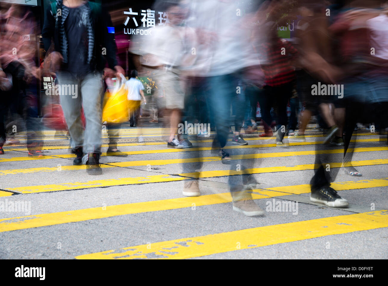 Pedoni in movimento sfocato mentre attraversano la Nathan Road, Kowloon, Hong Kong, Cina Foto Stock