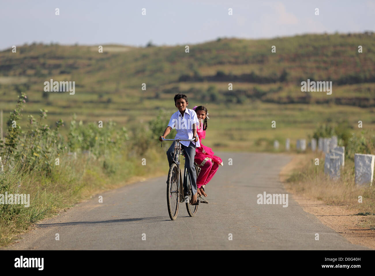 Indian un ragazzo e una ragazza, di sgombrare una bicicletta Andhra Pradesh in India del Sud Foto Stock