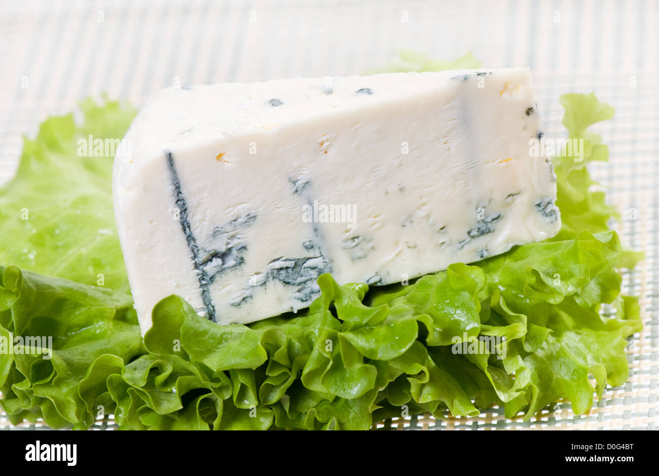 Formaggio erborinato Roquefort tratto giacente su lattuga Foto Stock