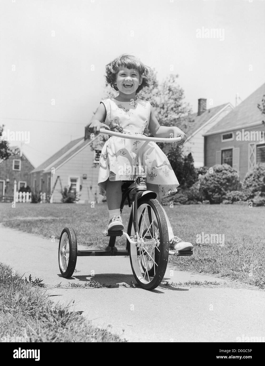 Ragazza sorridente sul triciclo Foto Stock