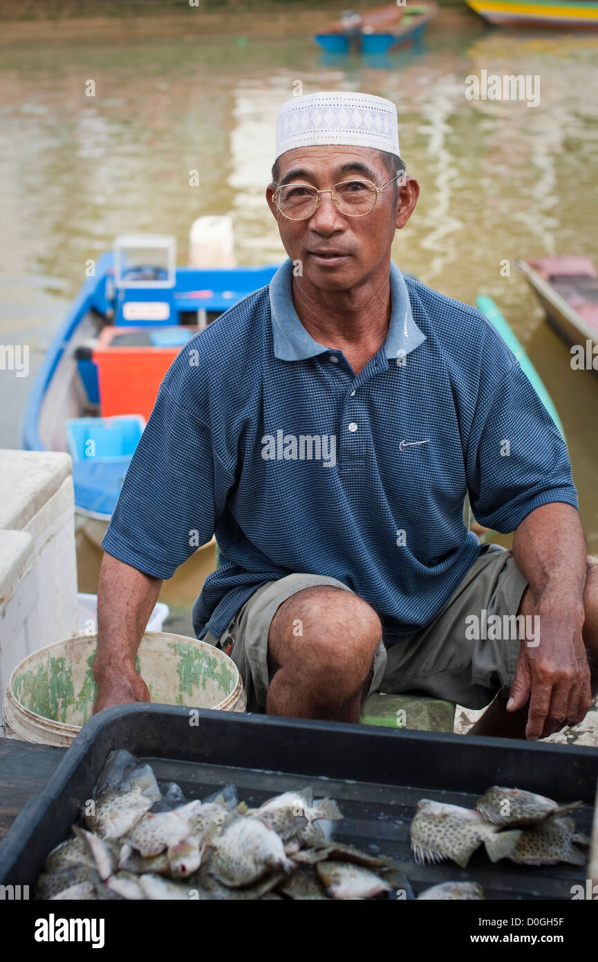 Un venditore di pesce con la sua produzione al mercato, Brunei Foto Stock