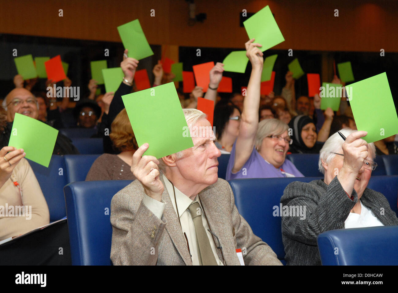 I delegati a una conferenza di caregivers utilizzando carte colorate per segnalare le loro intenzioni di voto, Londra, Regno Unito. Foto Stock