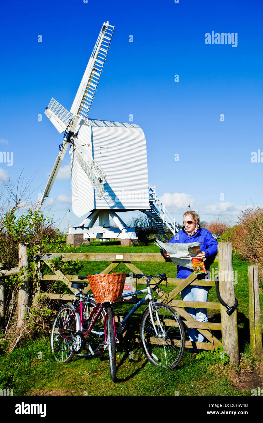 Una signora la lettura di una mappa con la sua bici davanti al mulino a vento weatherboard Chillenden a. Foto Stock