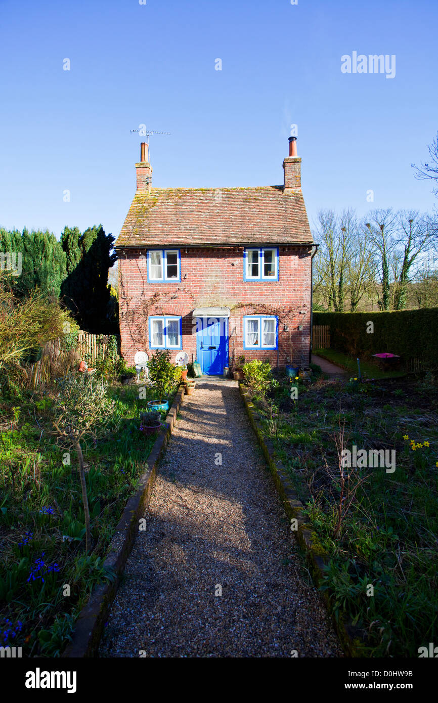 Un piccolo paese di lingua inglese cottage con dipinto di blu porta anteriore. Foto Stock