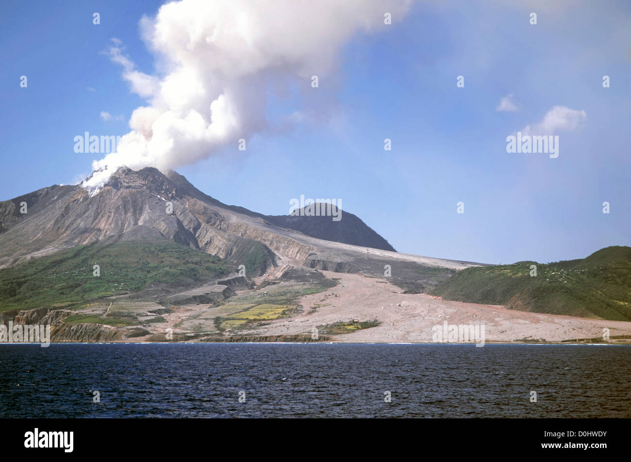 Il fumo del vulcano di Soufriere Hills sull isola caraibica di Montserrat eruzione dopo il disastro del 1997 con percorso di distruzione mediante flusso di lava in mare Foto Stock