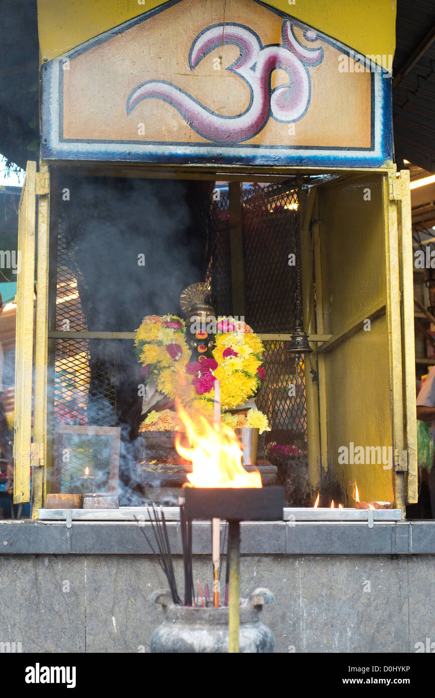 Un vassoio contenente la masterizzazione di canfora sorge nella parte anteriore di un Santuario Ganesh in Little India, Penang, Malaysia Foto Stock