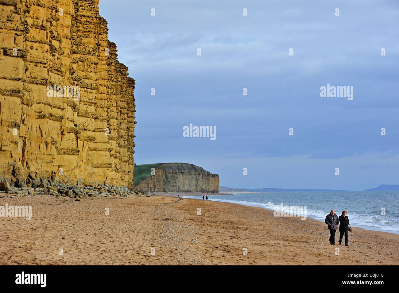Gli escursionisti a piedi sulla spiaggia di East Cliff, in pietra arenaria, vicino al West Bay lungo la Jurassic Coast, Dorset, Inghilterra meridionale, Regno Unito Foto Stock