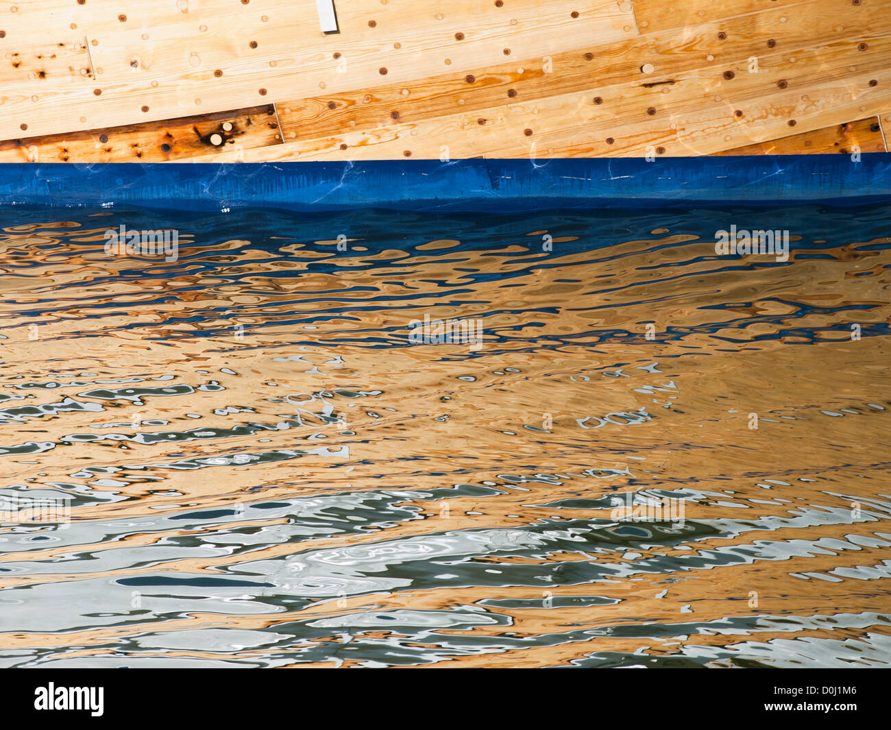 La barca di legno e la sua immagine riflessa sulle increspature nell'acqua di mare, Oslo Norvegia Foto Stock