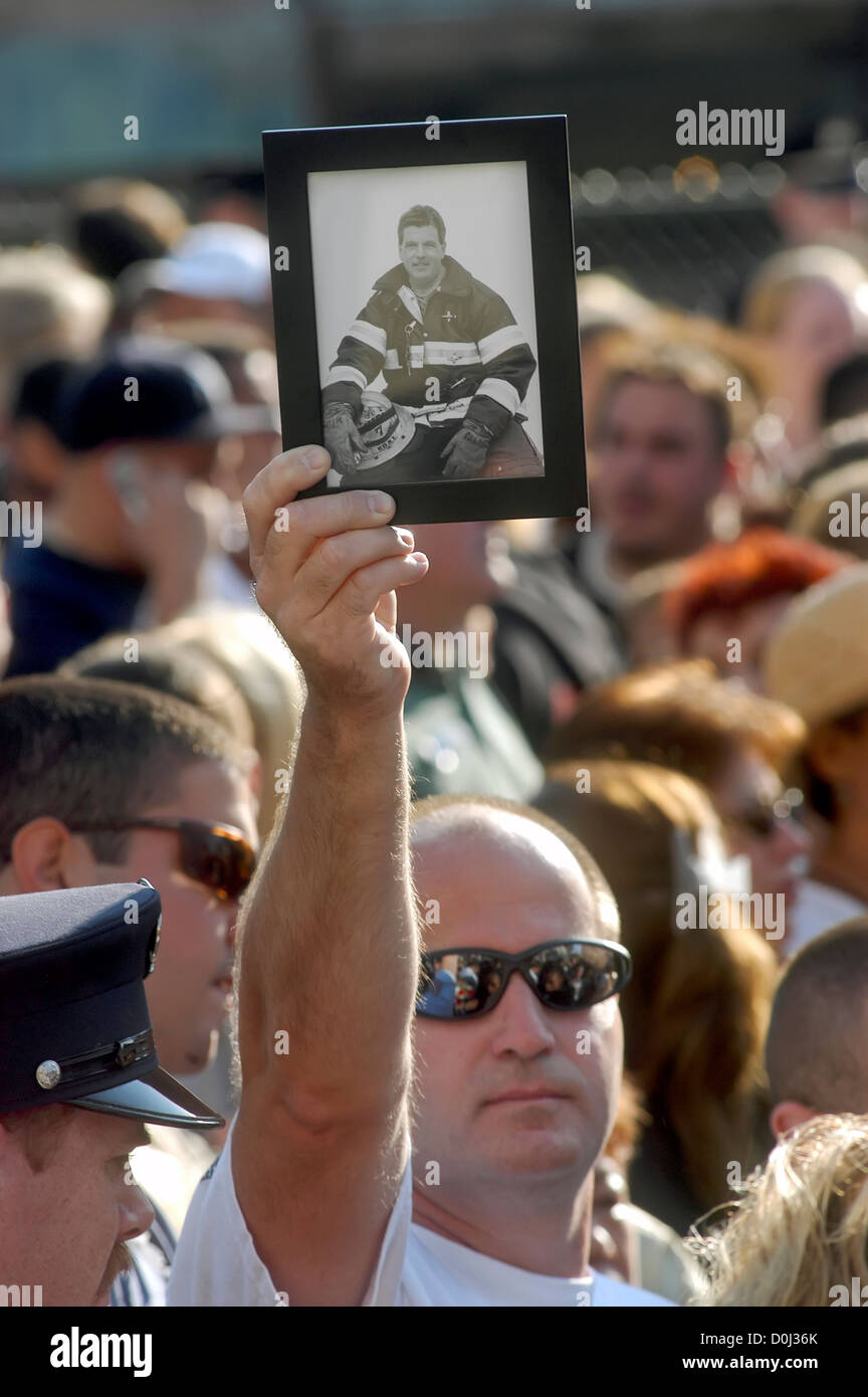 Famiglia membro detiene una foto di un vigile del fuoco in memoria a Ground Zero per il secondo anniversario del World Trade Center di attacco. Foto Stock