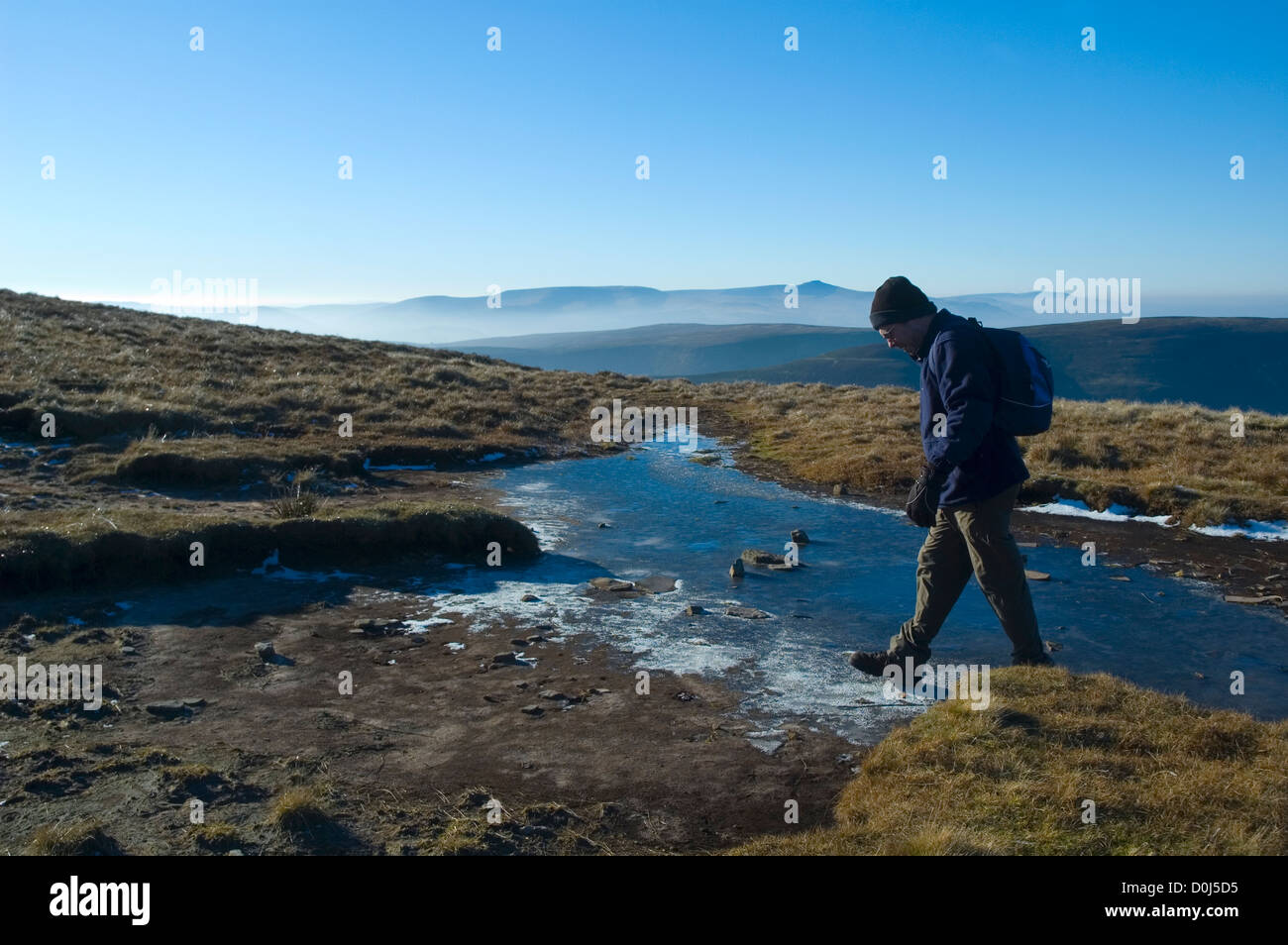 Un uomo a camminare in montagna nera area del Parco Nazionale di Brecon Beacons. Foto Stock