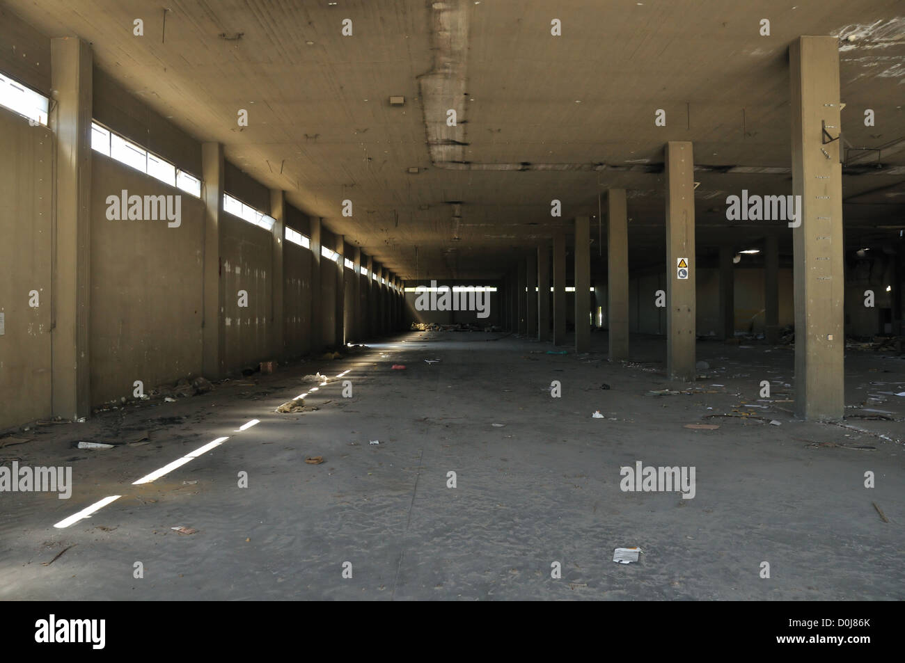 Il pavimento era sporco muro di cemento e soffitto in fabbrica abbandonata. Architettura Industriale. Foto Stock