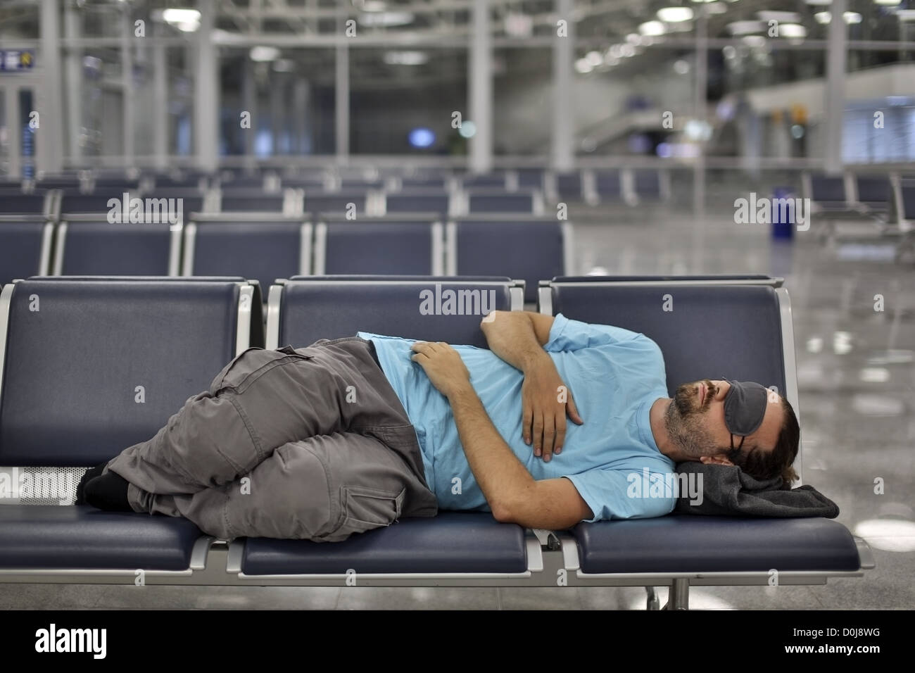Dormire in aeroporto con occhio coperchio Foto Stock