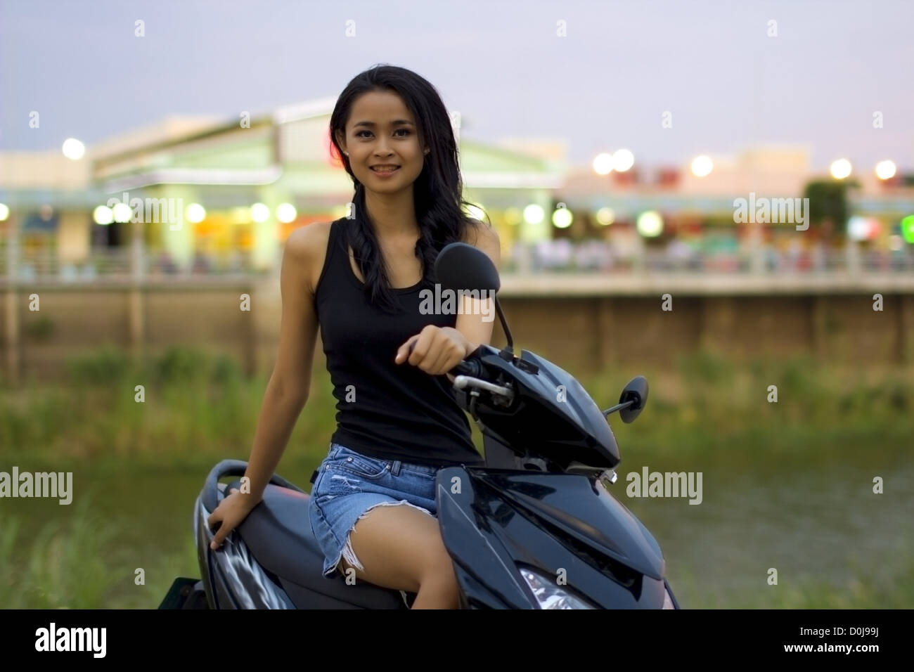 Sexy ragazza asiatica con mini gonna, casco, motociclo in Cambogia Foto Stock