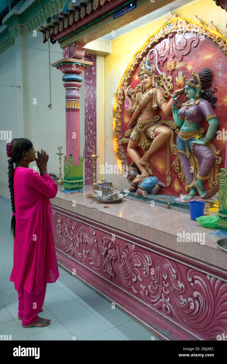 Un indù devoto prega a un santuario per la divinità Indù Shiva e la sua consorte Parvati nel Tempio di Sri Mariamman, Penang, Malaysia Foto Stock
