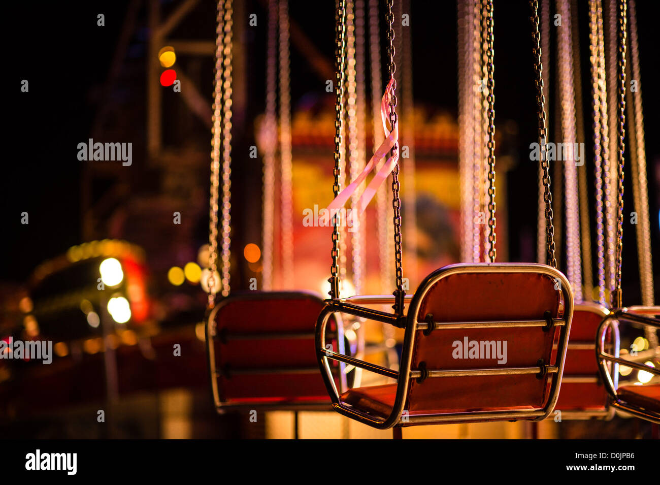 Aberystwyth, Wales, Regno Unito. Il 26 novembre 2012. Esattamente 8 settimane dopo la sua scomparsa, un singolo nastro rosa è legato ad una sedia vuota su un fairground ride in memoria di mancanti 5 anno di età bambino aprile Jones. Aberystwyth novembre luna park. Foto Stock