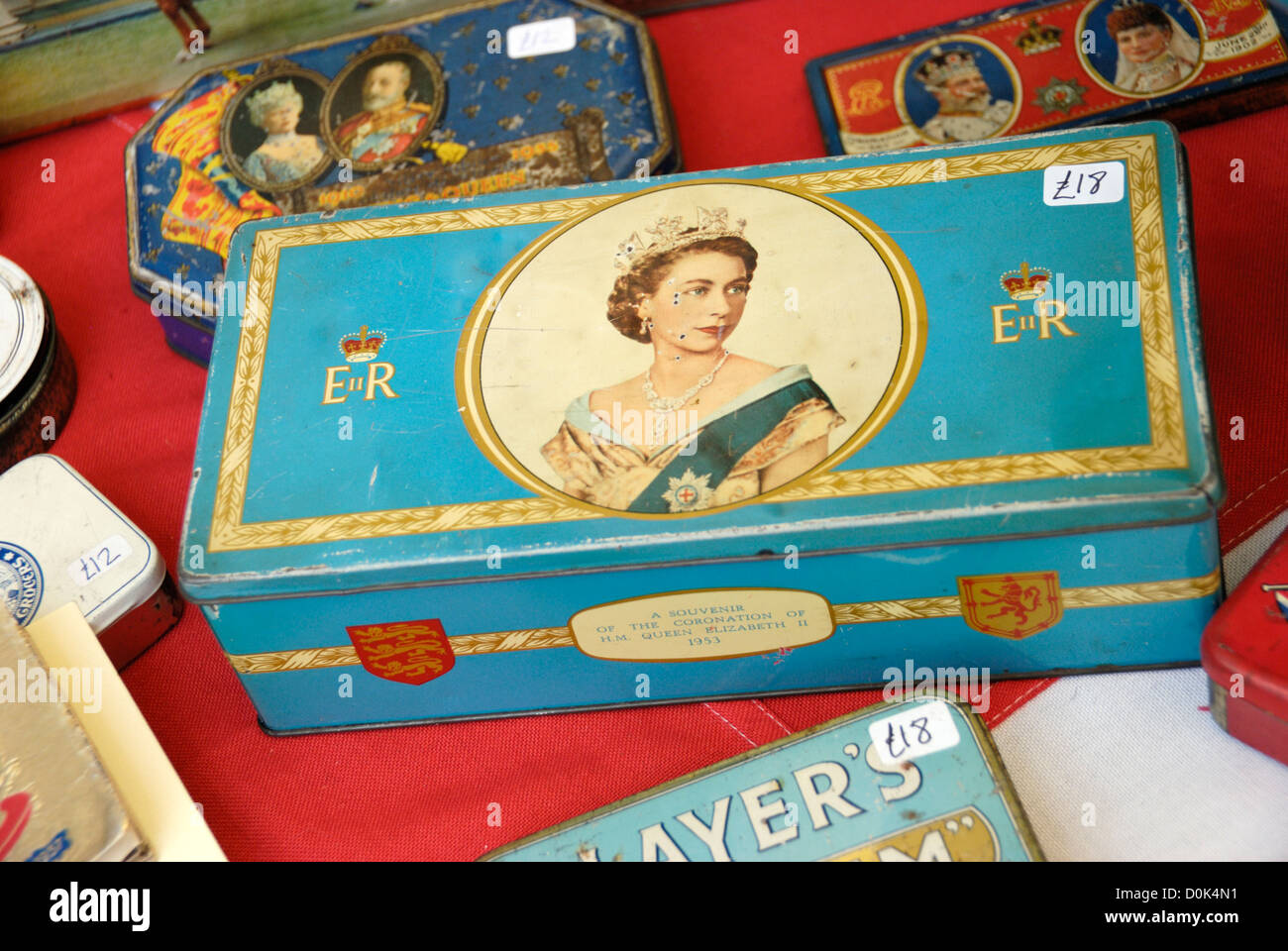 Scatole di Latta recanti immagini dei monarchi Inglesi per la vendita nel mercato di Portobello. Foto Stock