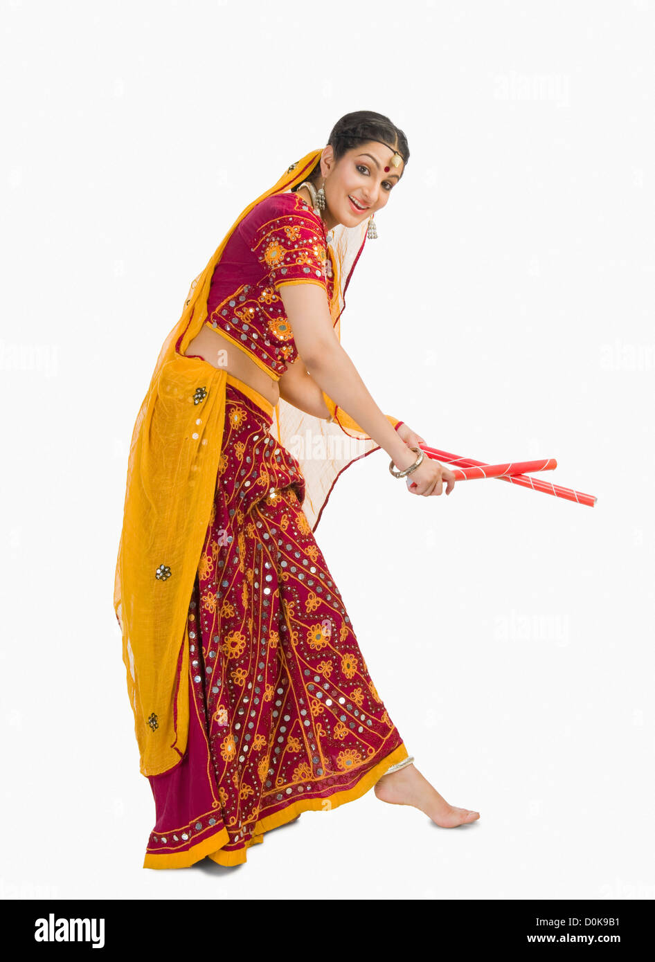 Donna in lehenga choli eseguendo dandiya dance Foto Stock